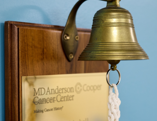 Bell for patients to ring signifying the end of cancer treatment. Includes MD Anderson Cancer Center at Cooper logo.