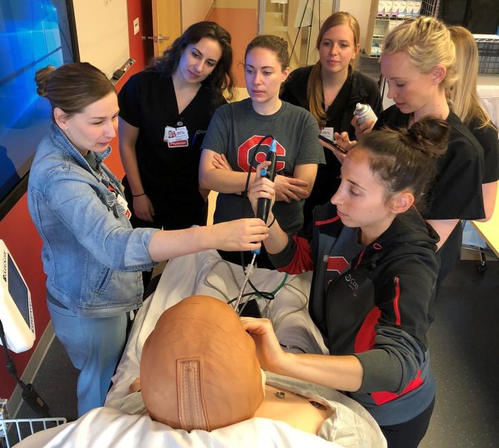 group of emergency medicine residents in the simulation laboratory learning how to scope a patient